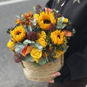 Композиция в сумке "Тональность" из подсолнухов, калл, ягод вибирнума, лимонных роз, скиммии и орхидеи в Куровском